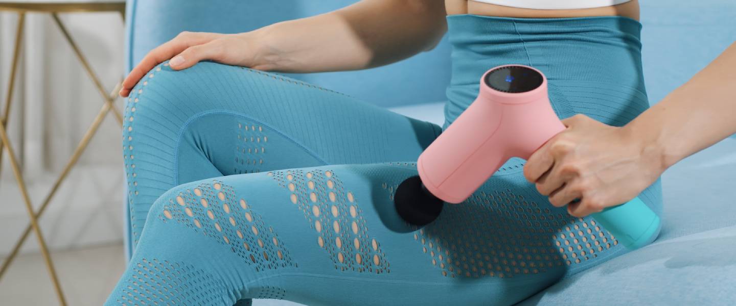 Viele Anwendungsmöglichkeiten der Massage-Gun für zuhause Kobieta używa pistoletu do masażu w domu na udzie w celu rozluźnienia mięśni