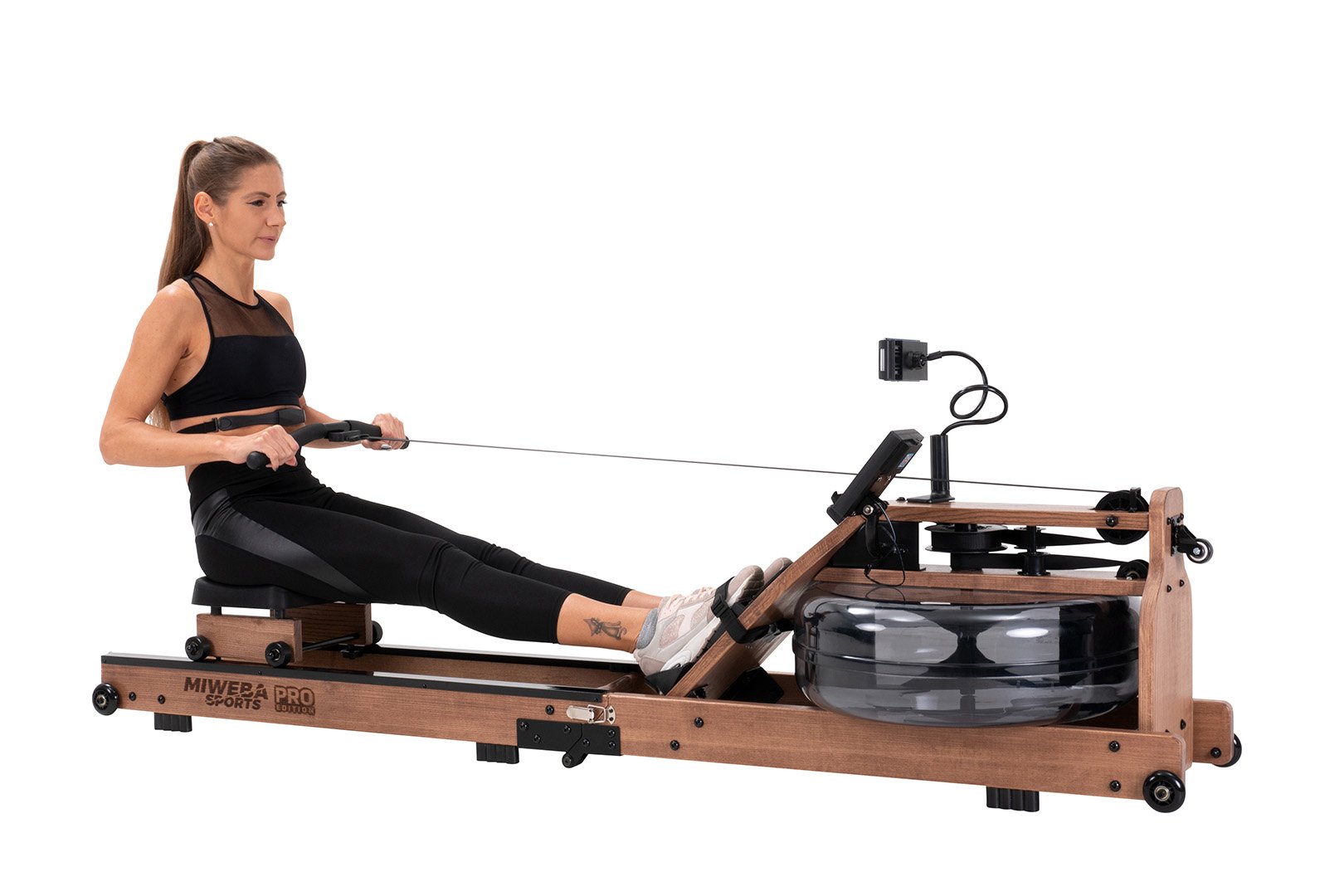 Zugphase auf dem Wasser-Rudergerät Sportlerin mit durchgestreckten Beinen auf der Rudermaschine während der Zugphase